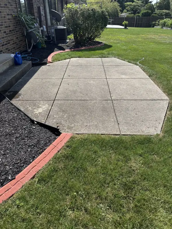 Columbia City concrete patio before cleaning, grey and dingy beside brick steps